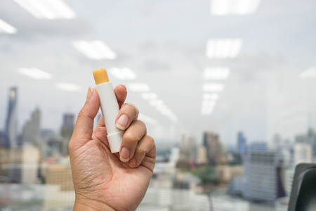 woman hold a lip balm in handの写真素材