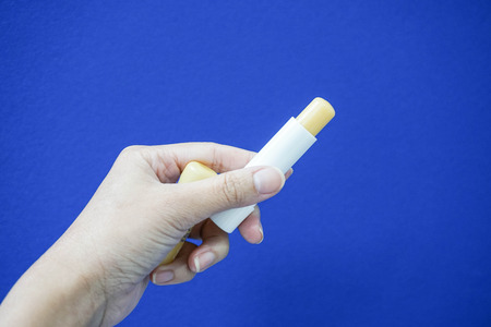 Hold a lip balm with woman handの写真素材