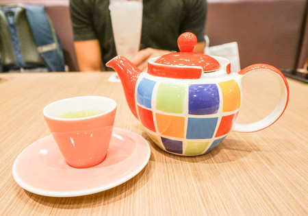 colorful ceramic teapot with cup and saucerの写真素材