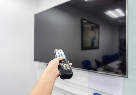 smart TV remote control in woman handの写真素材