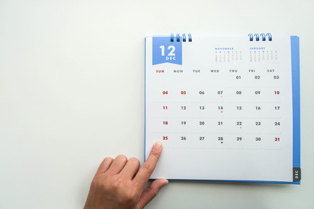 isolated woman point Christmas Day on December calendar by left forefingerの写真素材