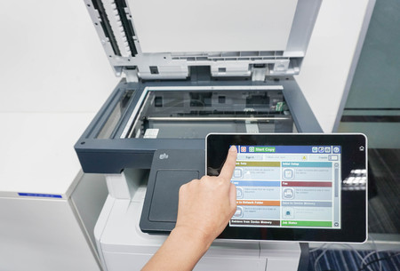 woman press forefinger on the printer touch screen to print documentsの写真素材