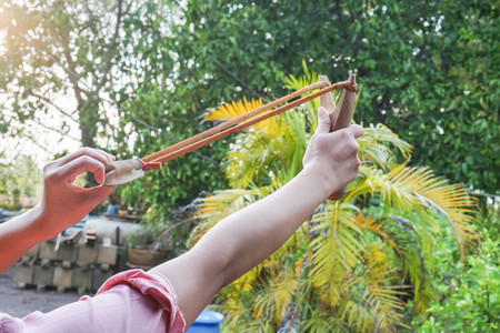 close up girl with slingshot for insects and bird hunting in rural areaの写真素材