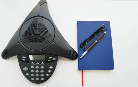 isolated voip IP conference phone with notebook for taking minute of meetingの写真素材