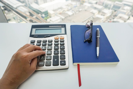 close up accountant left hand use calculator in officeの写真素材