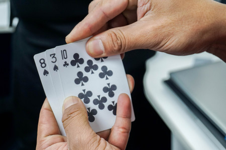 close up man play poker card in hands for gamblingの写真素材