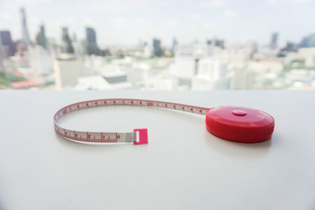 pink measure tape on white table with city view