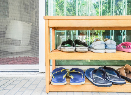 close up wooden shoes rack at the house doorの写真素材