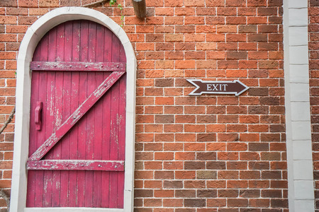 vintage style door with exit icon on brick wallの写真素材