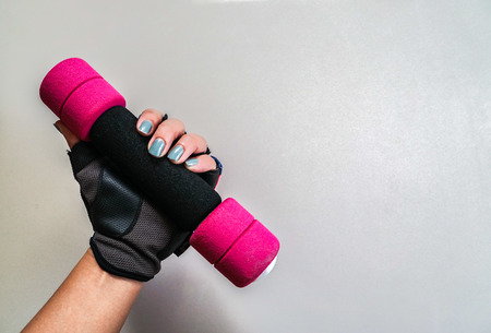 close up woman with fitness glove and cute pink dumbbell for exercise and weight losingの写真素材