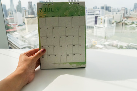 isolated woman hold mock up creative design July calendar in officeの写真素材