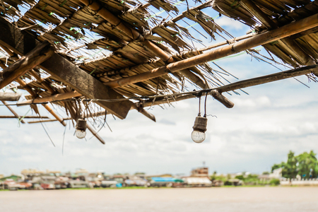 selective focus of vintage old lamp on dried nipa roof at riversideの写真素材