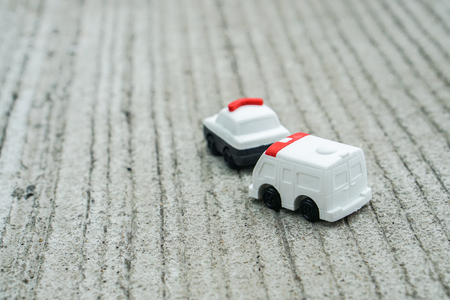 transportation concept - cute police car and ambulance van toy model on concrete roadの写真素材
