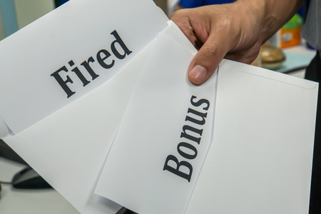 close up businessman with fired letter and bonus for employeeの写真素材