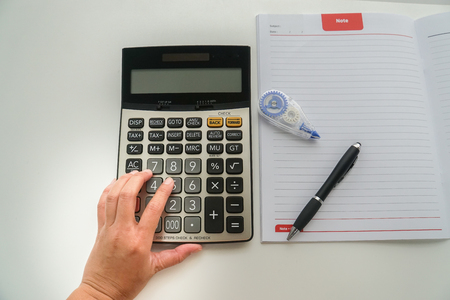 top view close up accountant with calculator, pen and correction fluid for tax and company income calculationの写真素材