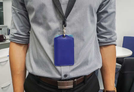 close up businessman with grey shirt and neck company badge in officeの写真素材