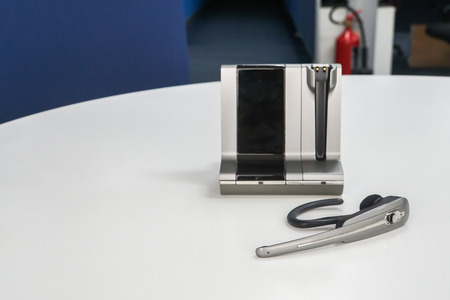business concept - close up wireless headset on office desk for communication and global conference callの写真素材