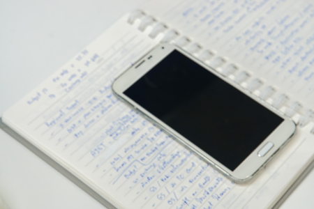 Business meeting concept - blurred minutes of meeting and smartphoneの写真素材