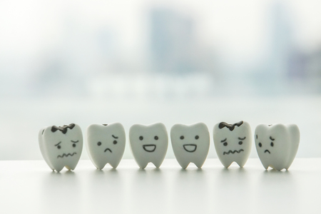 Human oral health icon - isolated healthy teeth and decayed teeth cartoon with smiley and sad faceの写真素材
