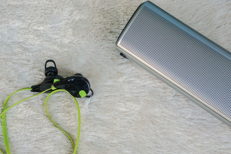 close up portable wireless speaker with headphones for listening on fur backgroundの写真素材