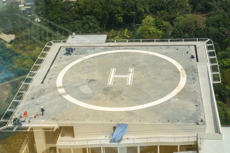 Helicopter park sign at the top of building with green park surroundingsの写真素材