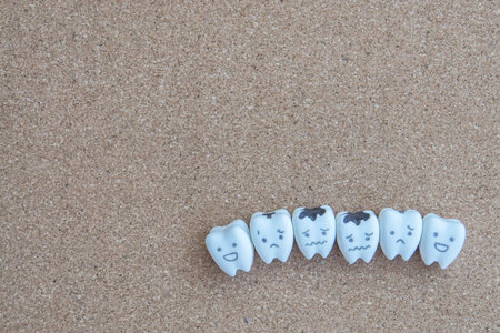 health concept - cute teeth cartoon of health and decayed icon on wooden cork background for...