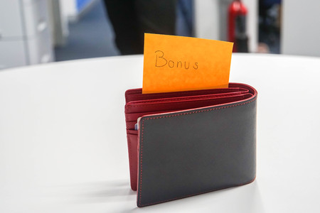 financial concept - employee yearly bonus in wallet for shoppingの写真素材