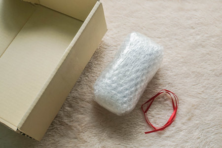 gift in bubble sheet with red ribbon and carton package for parcel