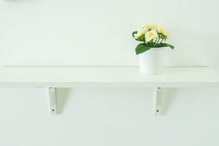 yellow artificial flower pot on wooden shelf decorated house interiorの写真素材