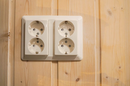 white socket outlet on wooden house wall
