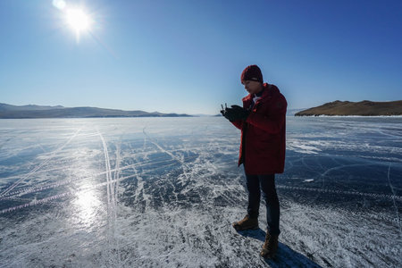 man use remote control for drone at frozen Baikal lake