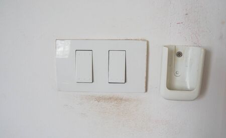 close up light switch and location of air conditioner remote on the bedroom wallの写真素材