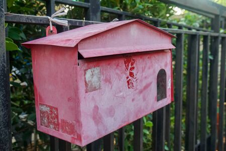 old red mailbox in front of the house doorの写真素材