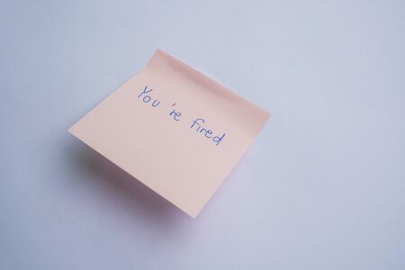 business concept of you are fired from the company handwritten on sticky noteの写真素材