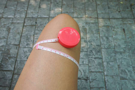 close up  measuring tape for woman thigh after working out for beauty and good shapeの写真素材