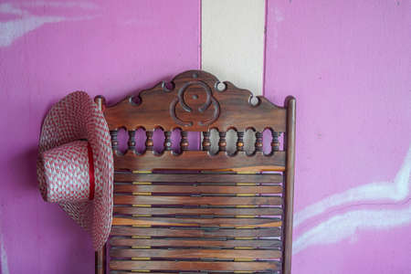 close up vintage straw hat on wooden chair at farm in countrysideの写真素材