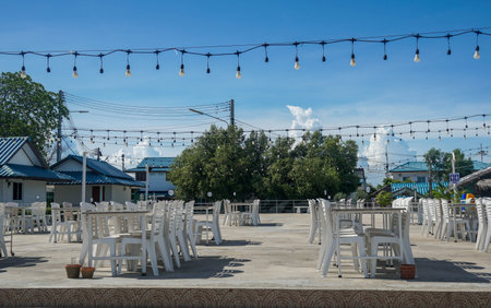 outdoor dining table at outdoor restaurant with vintage wire light bulb in sunny day
