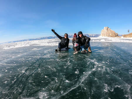 Baikal lake Irkutsk - February 14 2019: man and woman Thai people sit on frozen lake in Russia in winterの写真素材