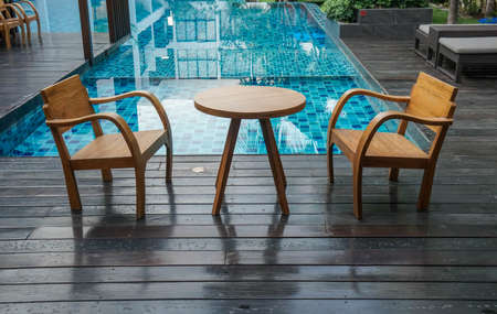wooden table and chairs at the poolside for breakfast in luxury hotelの写真素材