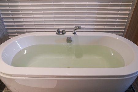 hot water in white ceramic bathtub in hotel bedroom