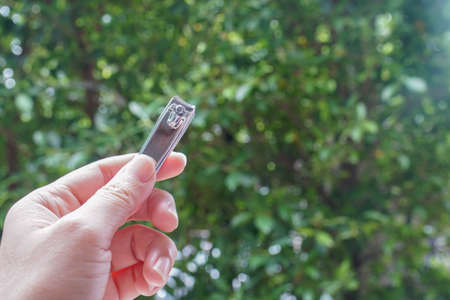 close up people hold stainless nail cutter with left hand for beautyの写真素材