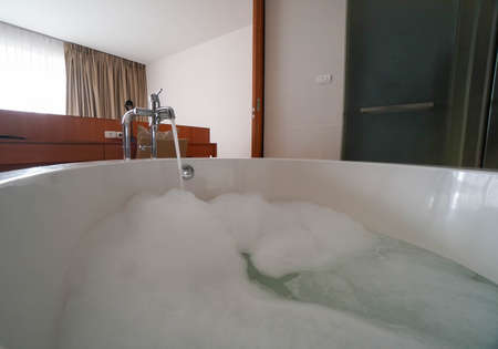 silhouette close up white bubble foam in sexy open bathtub with noise and grainの写真素材