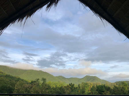 hill scenery outside the thatch roofの写真素材