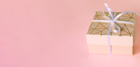 gift box with white ribbon on pink background