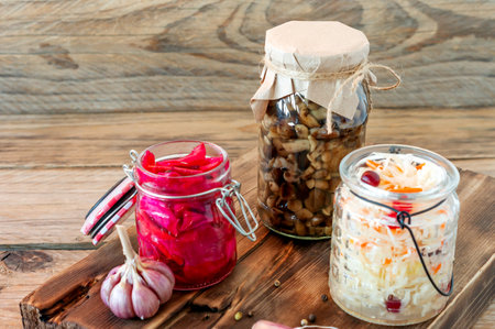 Sauerkraut variety preserving jars. Homemade Sauerkraut with Carrot and Salad Cabbage with Beetroot on a wooden table. Fermented foodの写真素材