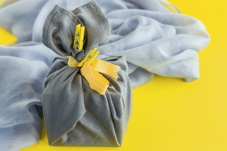 Zero waste, eco-friendly gift wrapping in traditional Japanese Furoshiki style, environmental concept, eco friendly banner. Trendy colors of the year 2021 Illuminating yellow and ultimate grayの写真素材