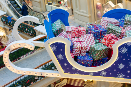 Moscow, Russia - December 15, 2020: Huge sleigh with christmas gifts holdung under ceiling at GUM...