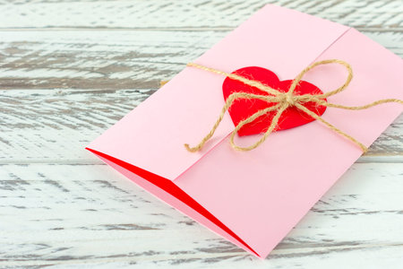 love letter with paper heart on wooden background. Festive greeting card for St Valentines day