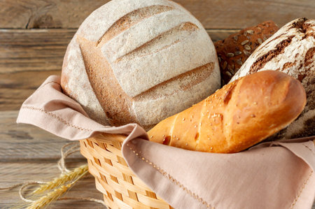 Composition of various baked products in basket on rustic background. Homemade fresh pastry