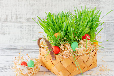 Easter basket with green grass filled with brightly colored Easter eggs. Happy Easter